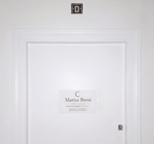 Puerta de entrada a la consulta de psicología de Marisa Bresó en Valencia, con el rótulo del centro